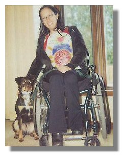 Photo: Julie in her wheelchair with her Service Dog Blue at her side - End Photo Description