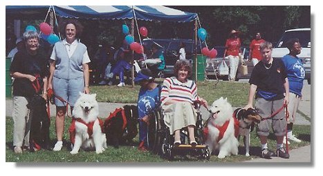Photo:  Joan Froling with friends and service dogs at community event - End of Photo Description
